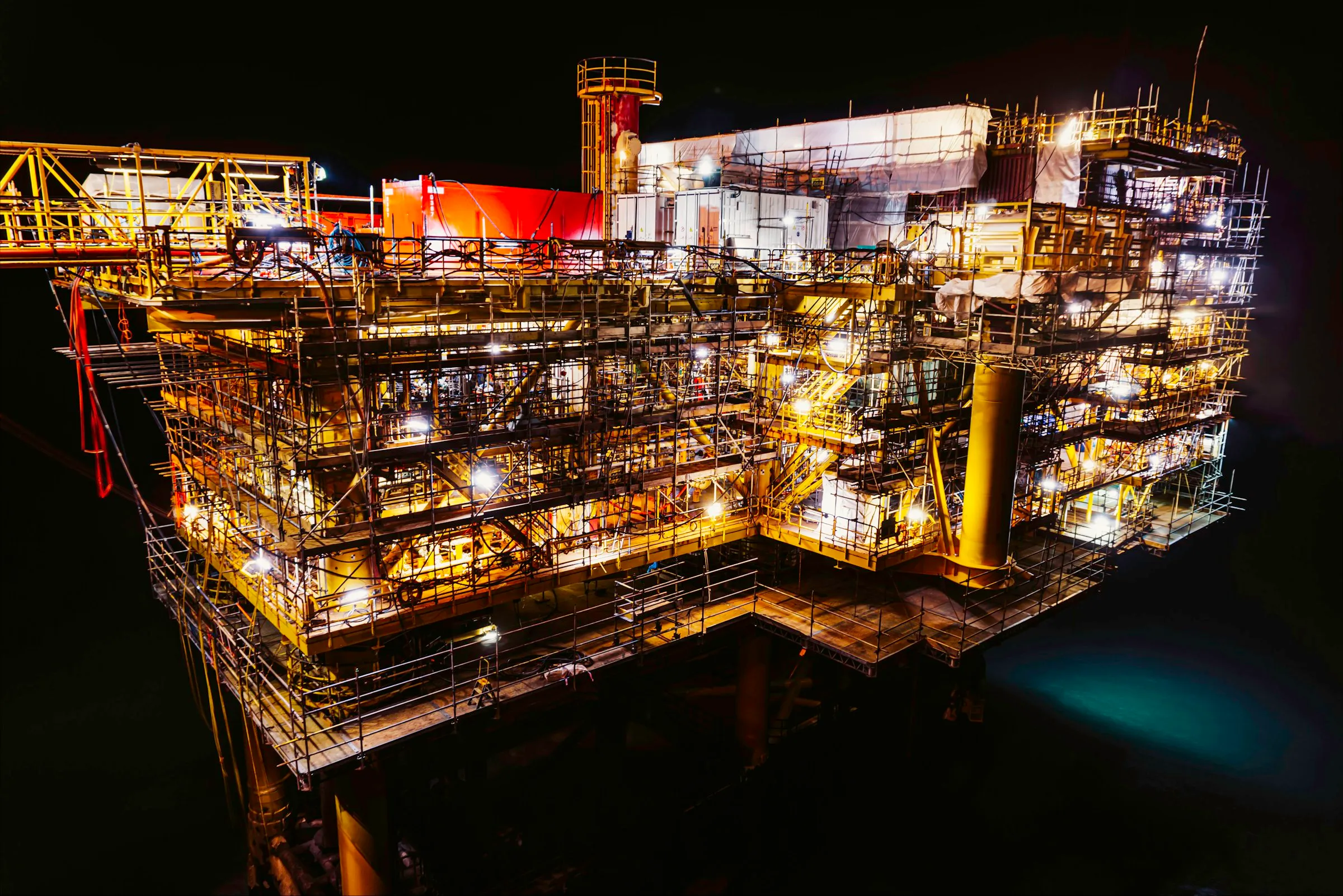 Offshore oil and gas platform lit at night
