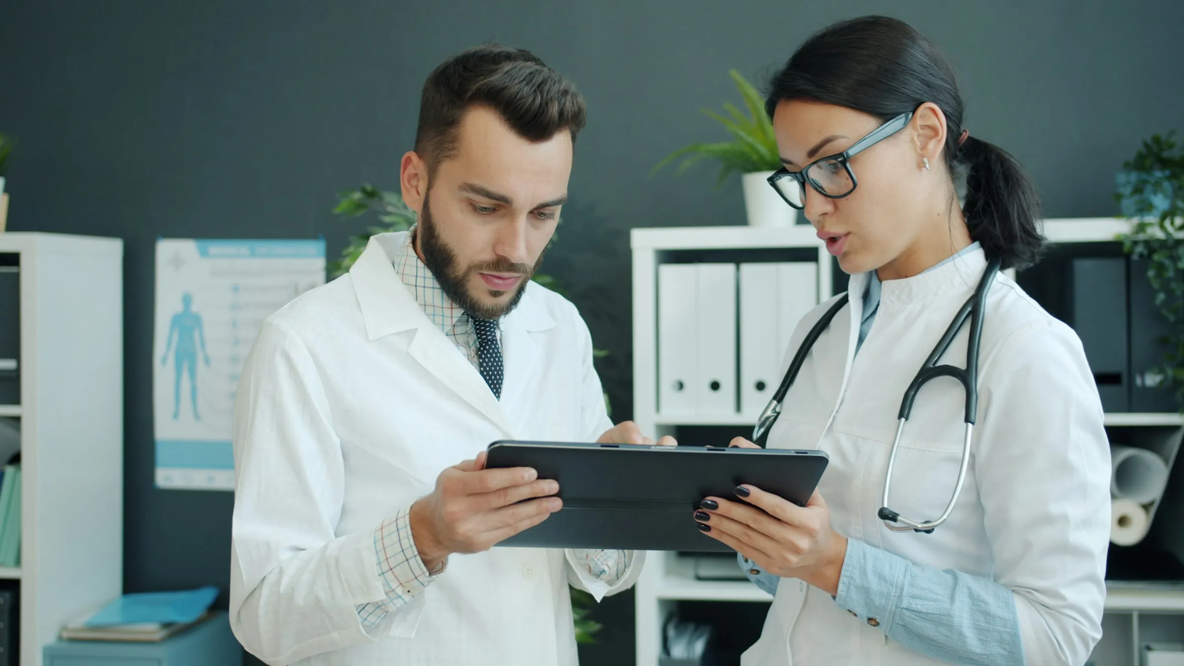 Two doctors reviewing information on a tablet