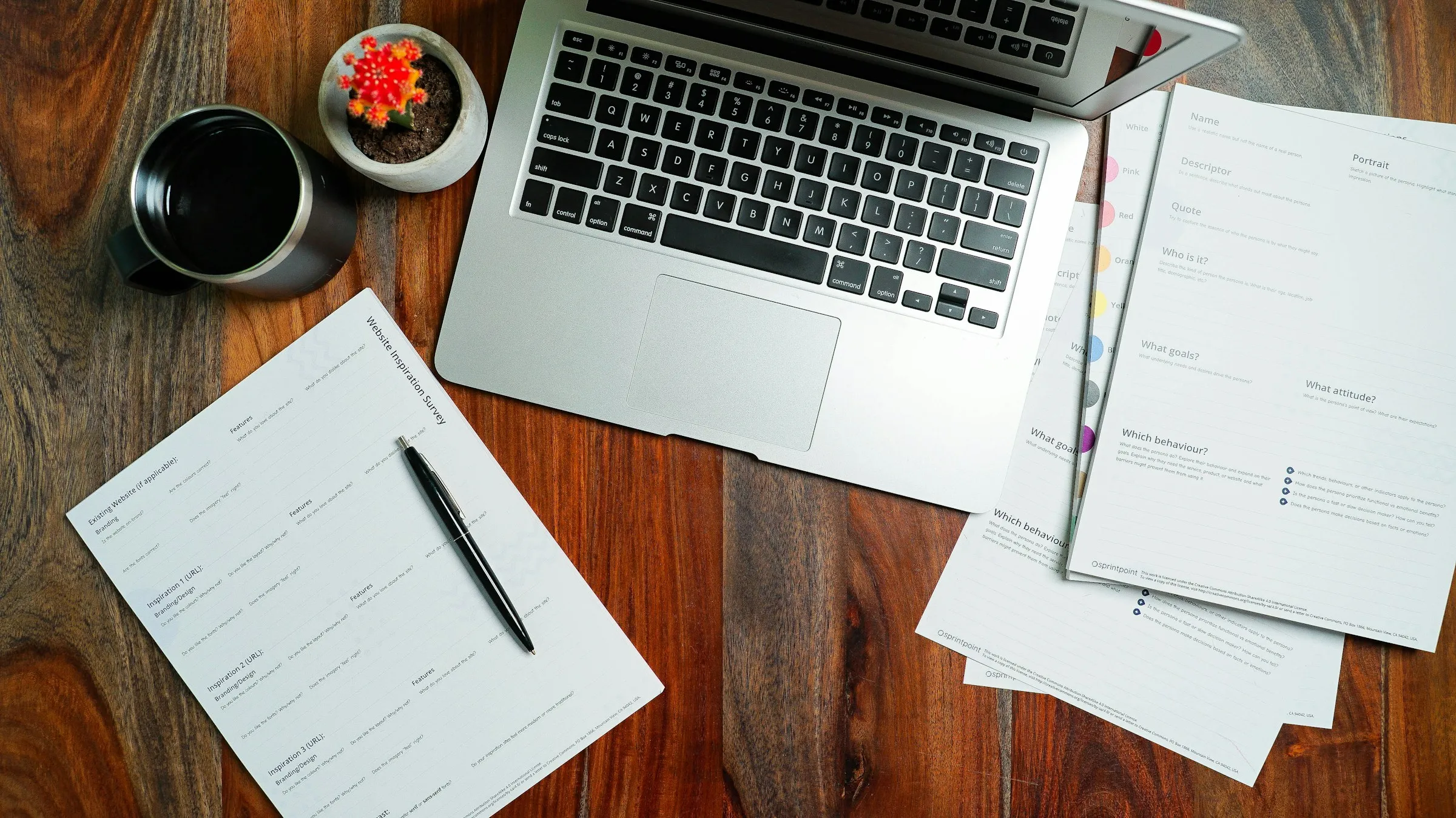 Laptop, documents and pen on a wooden desk