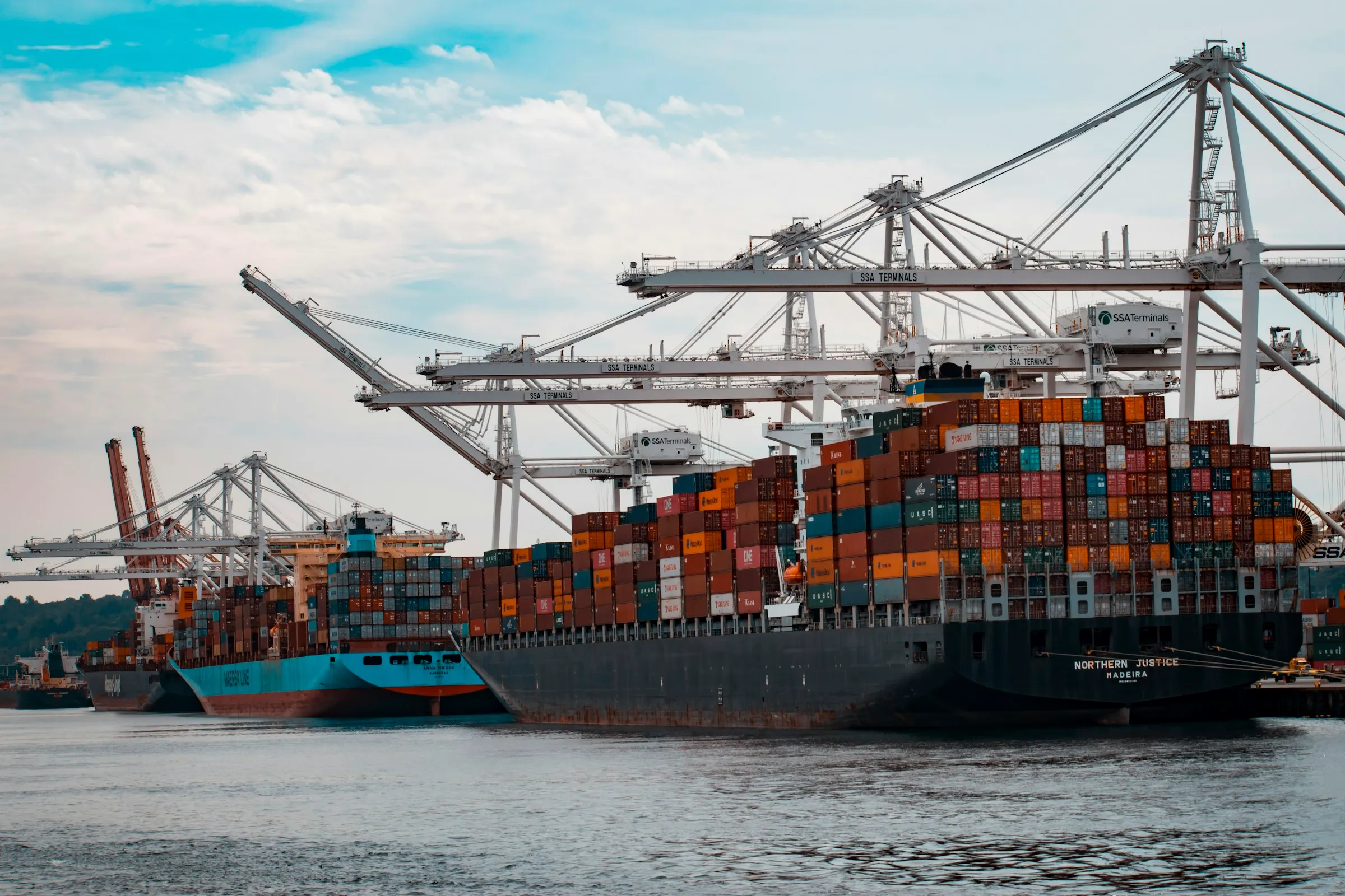 Container ship loaded beside port cranes