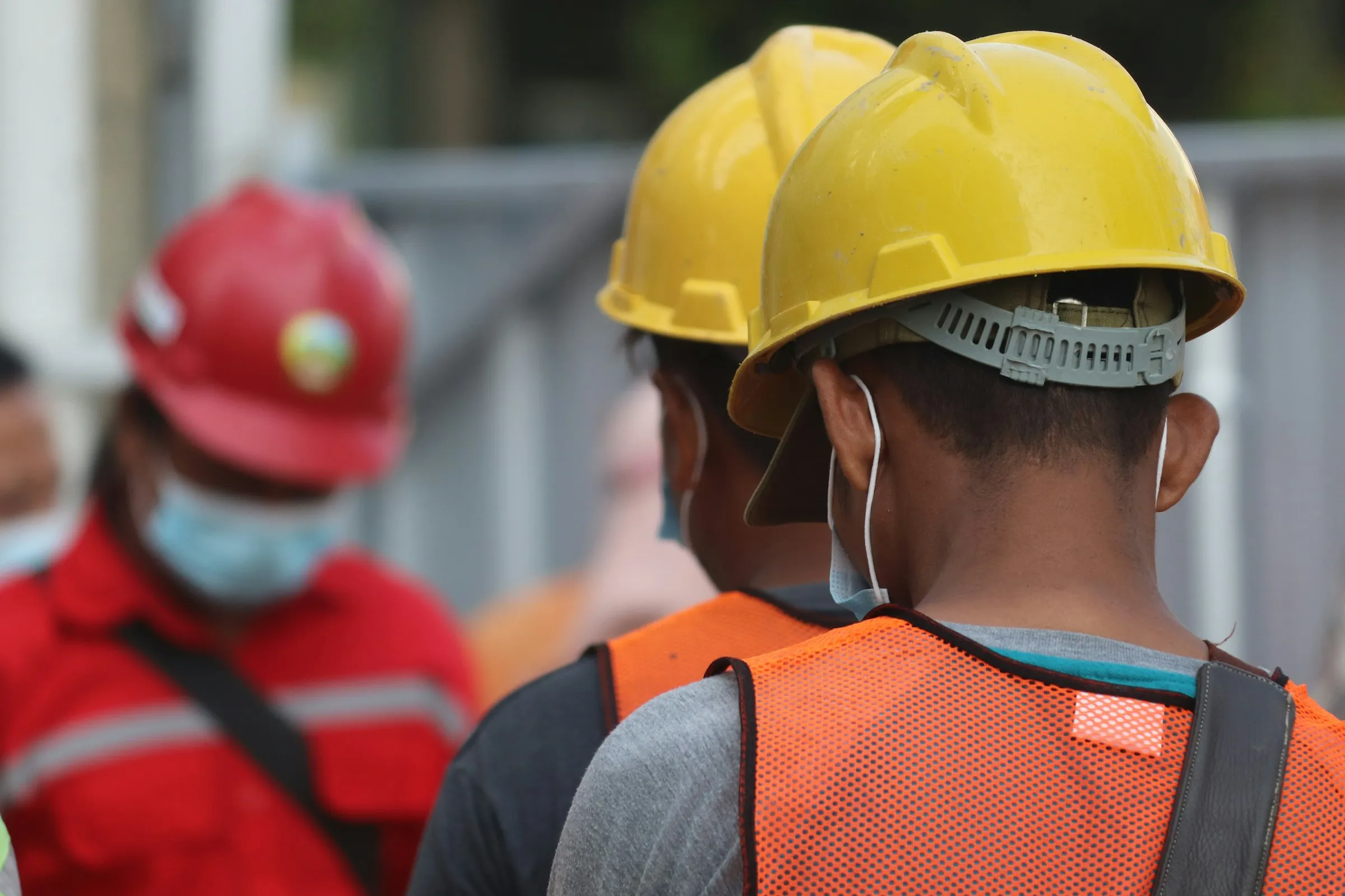 Workers in hard hats and face masks on site
