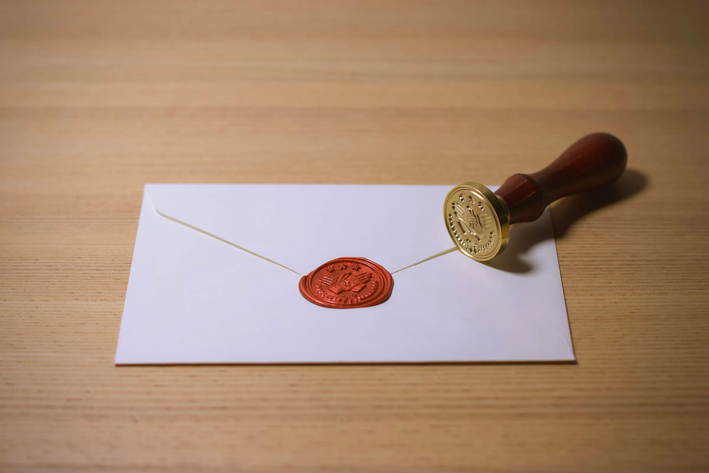 Wax seal stamp beside a sealed envelope