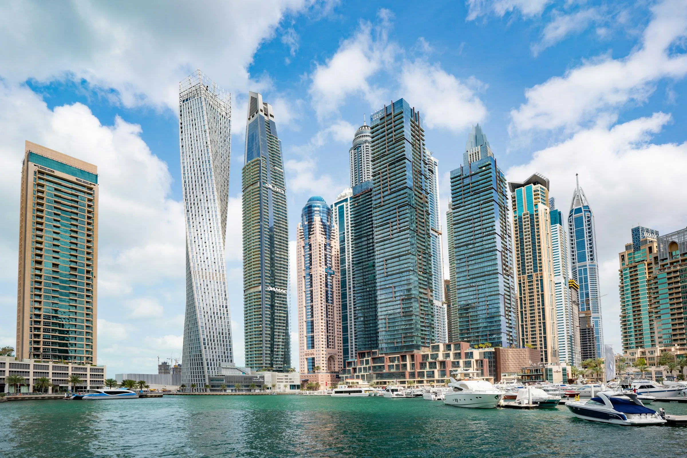 Dubai Marina towers and yachts under a blue sky