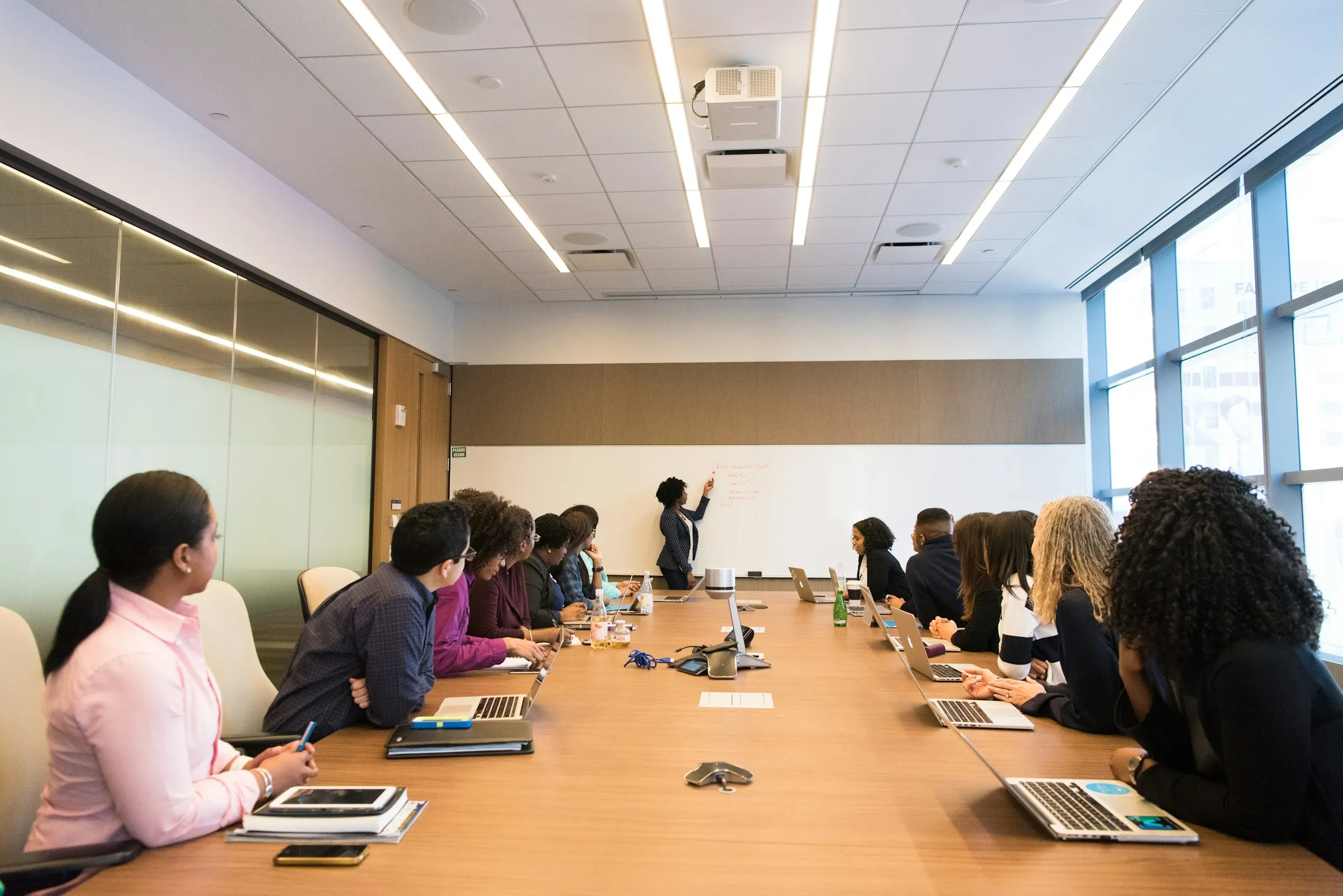 Team meeting along a long table in a bright conference room