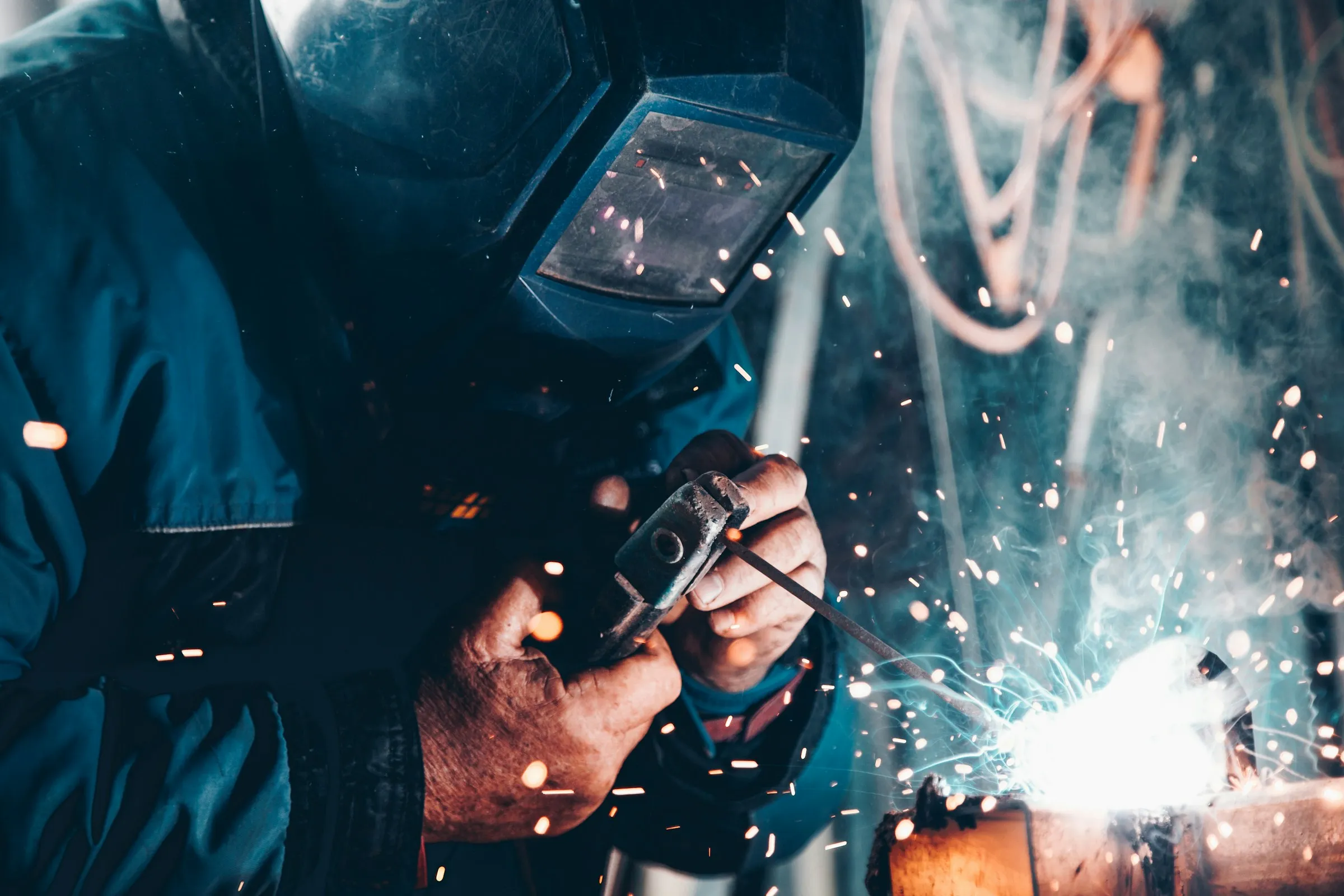 Welder in a mask working with bright sparks